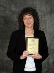 Picture of Dr. Merilee Krueger holding an award